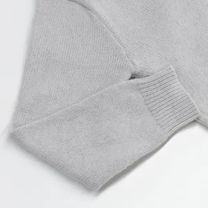 Detailed macro shot of light grey knitted sweater sleeve with fine rib cuff texture