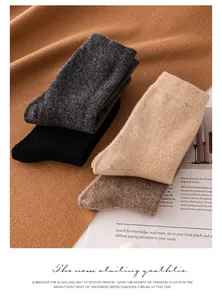 Macro view of thick solid color cashmere socks neatly stacked on warm textured fabric