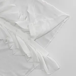 Vista detallada de una elegante blusa blanca con volantes y textura de la tela
