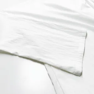 Détail en gros plan du vêtement de détente blanc montrant la texture et les coutures