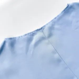 Detailed macro shot of light blue satin fabric and fine stitching on elegant evening dress