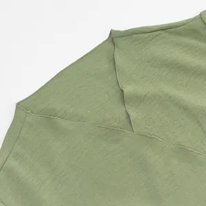 Detailed close-up showing the soft sage green knit fabric and V-neckline of an elegant dress
