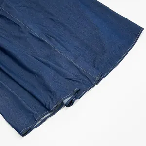 Detail view of the fine stitching and texture on a long blue denim dress hem