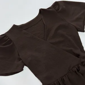 Close-up of elegant dark brown V-neck short sleeve dress with textured fabric detail