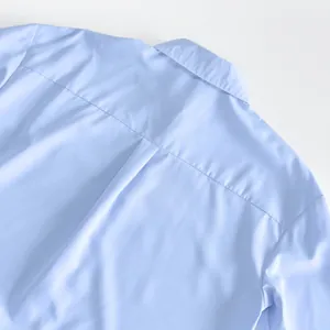 Close-up detail shot of the back collar and shoulder fabric on a light blue French shirt dress