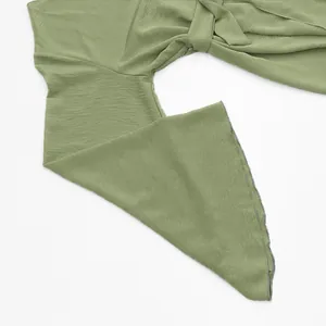 Detail showing the sage green textured fabric and tie-up knot of this elegant dress