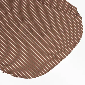 Vue détaillée de l'ourlet incurvé et des coutures sur un tissu en satin à rayures.