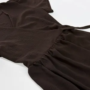 Close-up detail of high-quality dark brown crinkle fabric dress with gathered waist