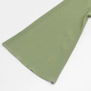 Detailed close-up of a sage green flared sleeve from an elegant women's dress.