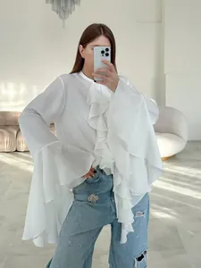 Detalle de blusa blanca estilo francés con volantes en capas y mangas largas de diseño