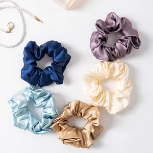 Set of five elegant silk scrunchies in various colors on a clean white background
