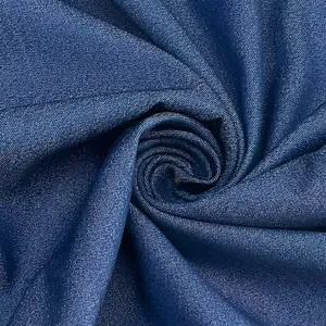 Close-up view of blue denim fabric texture with a stylish spiral fold arrangement