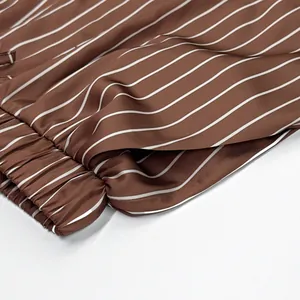 Détail de la taille élastique et de la poche sur le short en satin à rayures marron et blanc