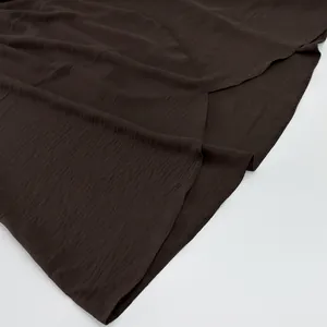 Close-up of elegant chocolate brown pleated fabric texture for women's summer long dress.