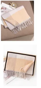 Detail view of high quality yellow and grey plaid cashmere scarf with soft fringes