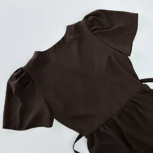 Close-up of brown puff sleeves and elegant neckline on a textured maxi summer dress