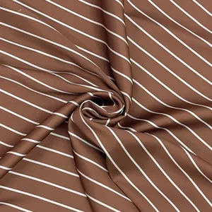 Détail du tissu en satin à rayures marron et blanc montrant sa texture lisse et son drapé
