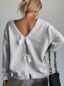 Detailed view of white bows on a French-style deep V backless grey knitted sweater