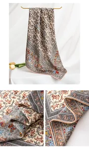 Detailopname van een luxe zijden wollen sjaal met verfijnde Paisley dierenprint en rand.