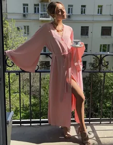 Detailed view of an elegant pink wrap cardigan maxi dress in a lifestyle balcony setting