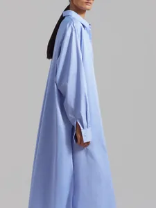 Detailed side view of long oversized light blue shirt dress featuring elegant drape