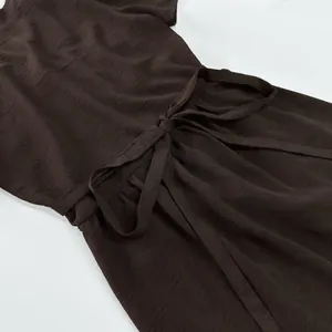 Close-up detail of an elegant coffee brown summer dress with adjustable tie-waist