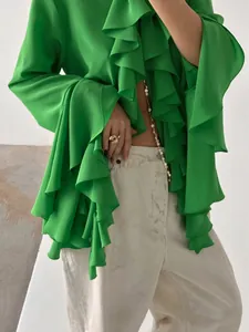 Detalle de blusa verde de manga larga estilo francés con volantes y textura