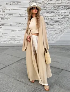 Elegant long beige cardigan paired with white crop top and wide-leg trousers