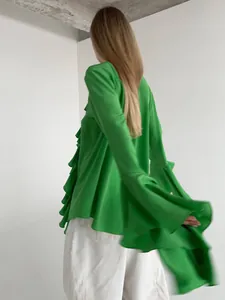 Vista detallada de la espalda de una blusa verde de manga larga con volantes elegantes