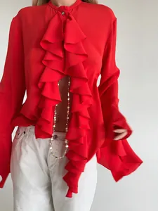 Detalle de una blusa roja con volantes y mangas largas de estilo francés elegante