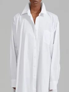 Detailed macro view of a white French style long-sleeve shirt dress with chest pocket