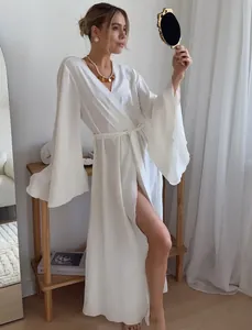 Elegant white wrap dress featuring dramatic flared sleeves and a waist tie detail