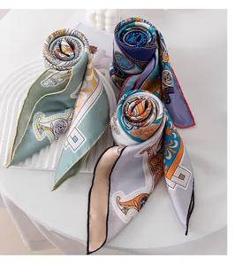 Close-up of three rolled mulberry silk scarves with intricate colorful patterns and silk texture