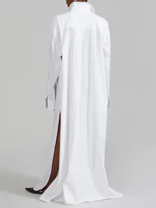 Back view of a white maxi shirt dress with high side slits and a minimalist design.