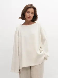 Gros plan sur un pull en maille oversize minimaliste à col bateau en pur coton doux de qualité