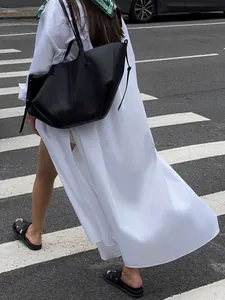 Model wearing a French style white long shirt dress with side split for vacation