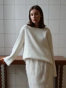 Pull en tricot blanc minimaliste et jupe à franges texturée sur un mannequin de mode