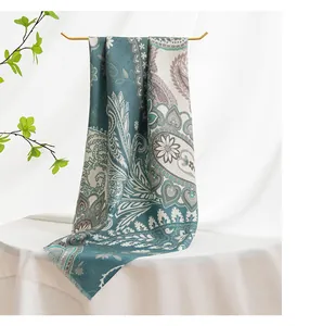 Detailed view of blue paisley silk wool scarf featuring twill texture and fringed edges