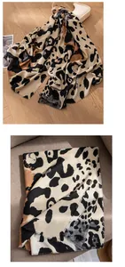 Nahaufnahme eines eleganten beige Leoparden-Schals mit Quasten für den Herbst