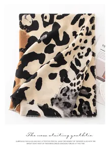 Detailaufnahme eines beigen Schals mit Leopardenmuster, Fransen und weicher Textur