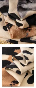 Makroaufnahme eines beigefarbenen Schals mit Leopardenmuster und weicher Textur.
