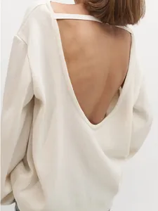 Détail de la vue arrière d'un pull en maille de coton blanc avec un design dos nu en V profond