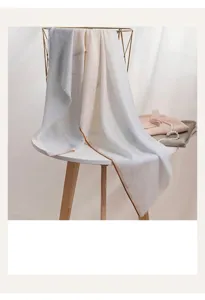 Vue détaillée d'une écharpe en laine minimaliste avec texture gaufrée et drapé élégant sur table