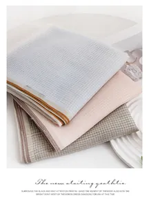 Detailansicht von drei gefalteten Wollschals mit weicher Waffelstruktur-Textur.