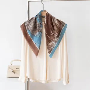 Close-up of 100% cashmere printed square scarf with palm leaf pattern on shirt