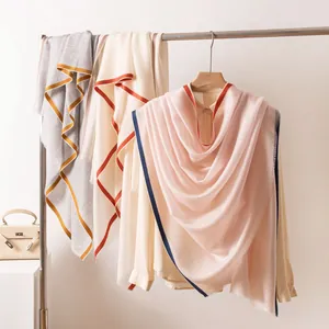 Elegante, leichte Wollschals in verschiedenen Farben an einer minimalistischen Kleiderstange