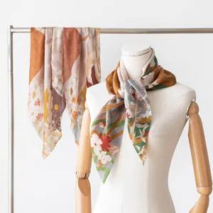 Styling of a 100% cashmere printed square scarf on a wooden mannequin for fall fashion