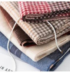 Detailed texture view of stacked 100% wool plaid scarves in elegant autumn colors
