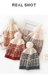 Close-up of four colors of knitted wool beanies with soft pom-poms for winter.