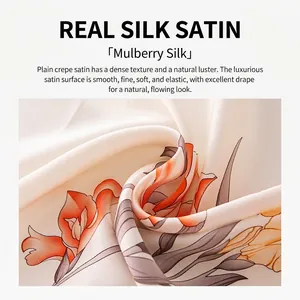 Elegant mulberry silk scarf featuring vibrant orange camellia floral prints and smooth satin.